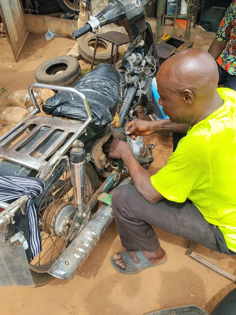 Mekanik memperbaiki motor di bengkel